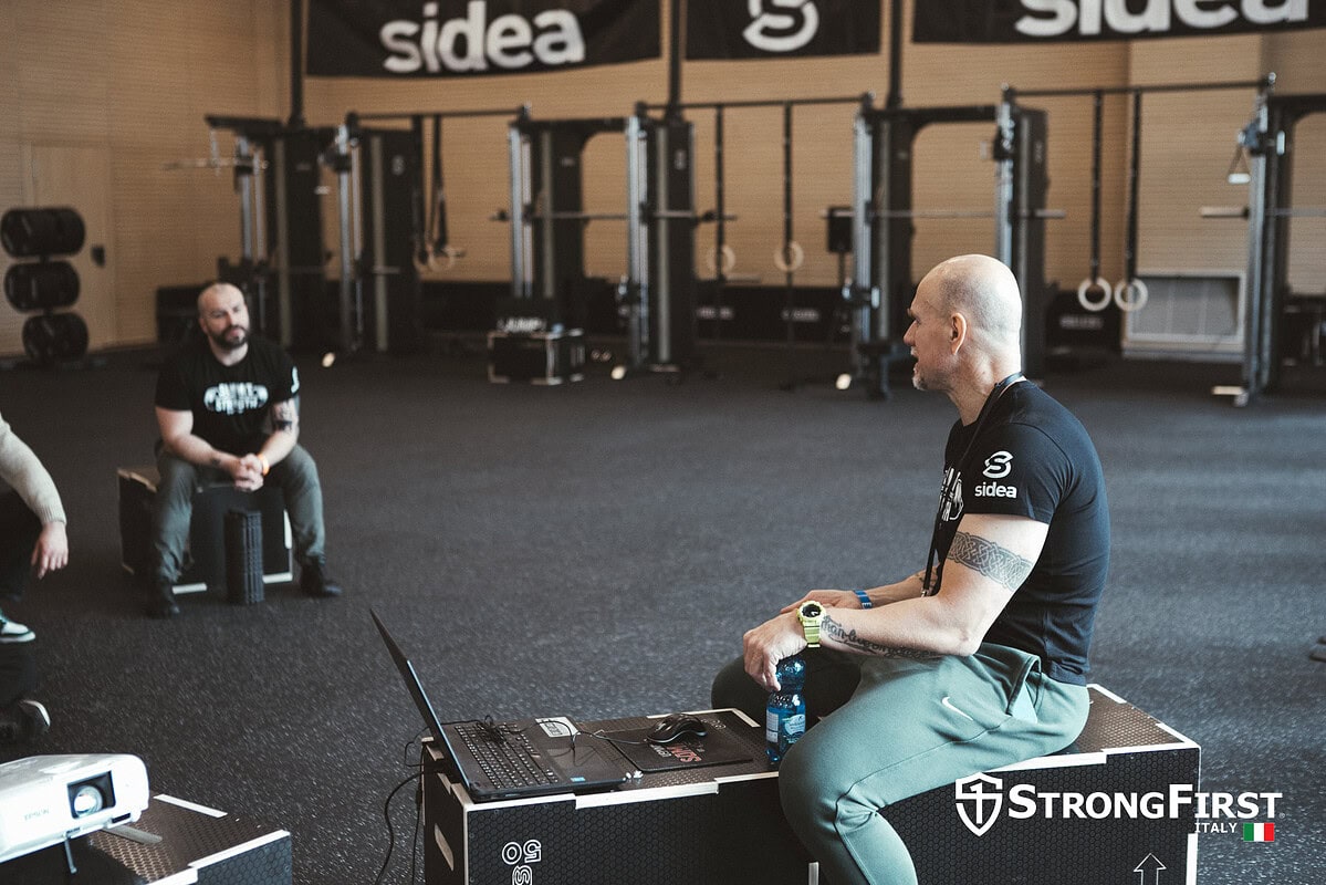 Allenamento funzionale con attrezzature professionali Sidea in palestra moderna, con istruttore che guida un gruppo di atleti. Ambiente attrezzato e motivante per migliorare le performance sportive.