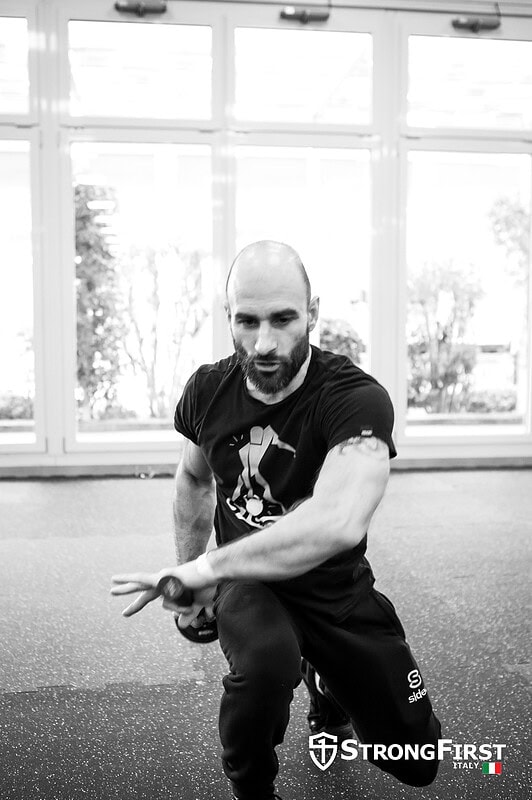 Uomo che esegue esercizio di allenamento 3D con attrezzatura fitness professionale in palestra moderna, promuovendo forza e benessere.