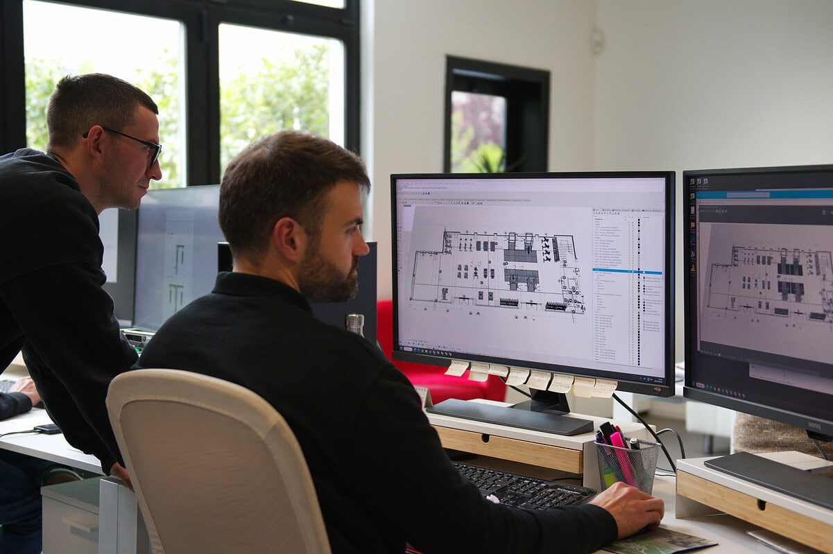 Due professionisti al lavoro su un progetto di home gym, con software di progettazione per creare uno spazio fitness personalizzato e funzionale.