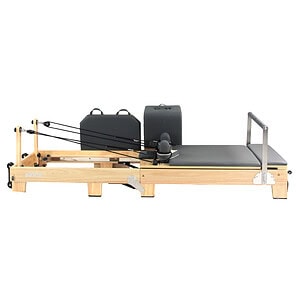 Equipo profesional de Pilates Reformer con resistencias y estructura de madera y metal para ejercicios de Pilates.